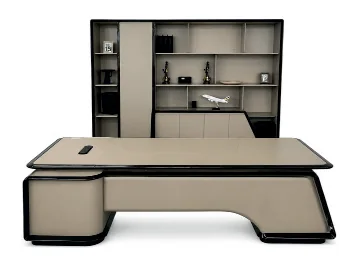 Grey executive desk with a curved base and a tall shelved file cabinet behind it
